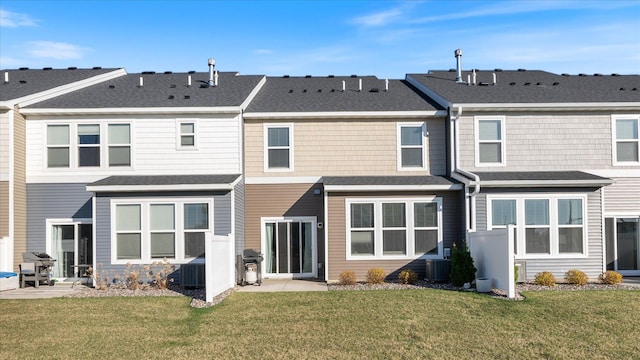 rear view of property featuring a lawn, a patio area, and central air condition unit