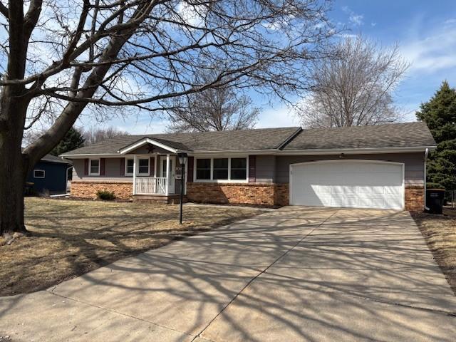 ranch-style home featuring concrete driveway, a garage, and brick siding
