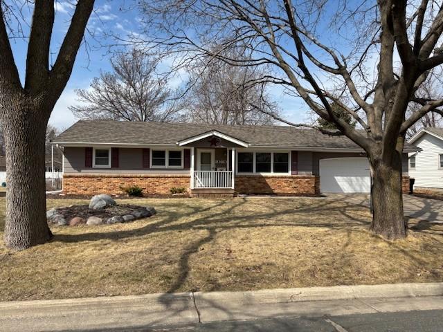 single story home featuring a garage, covered porch, and brick siding