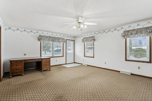 unfurnished office featuring a healthy amount of sunlight, light colored carpet, ceiling fan, and visible vents