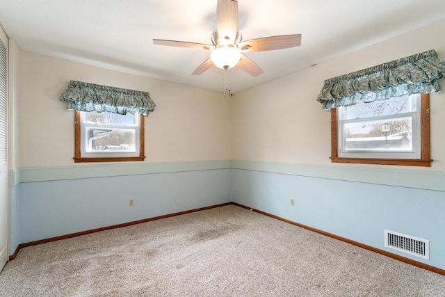 spare room with visible vents, baseboards, a ceiling fan, and carpet floors