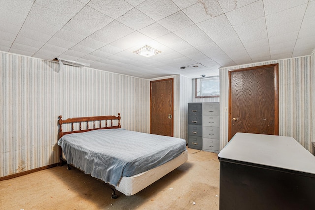 bedroom featuring wallpapered walls and concrete flooring