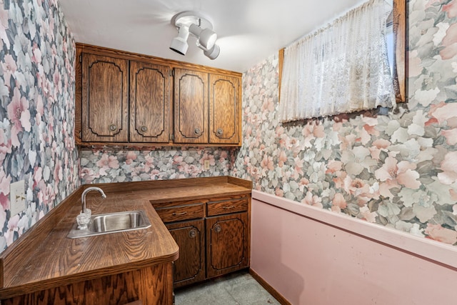 kitchen featuring wallpapered walls and a sink