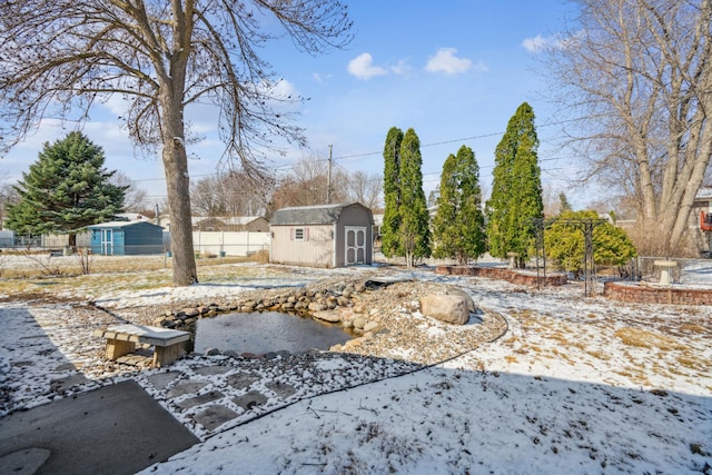 view of yard with an outdoor structure, fence, and a storage unit
