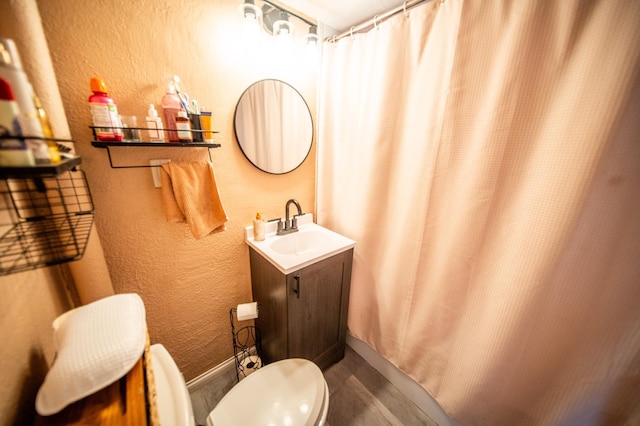 full bathroom with baseboards, a textured wall, vanity, and curtained shower