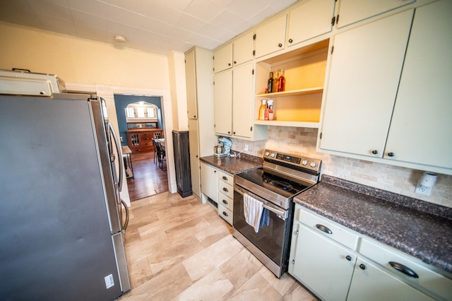 kitchen featuring open shelves, tasteful backsplash, cream cabinetry, and stainless steel appliances