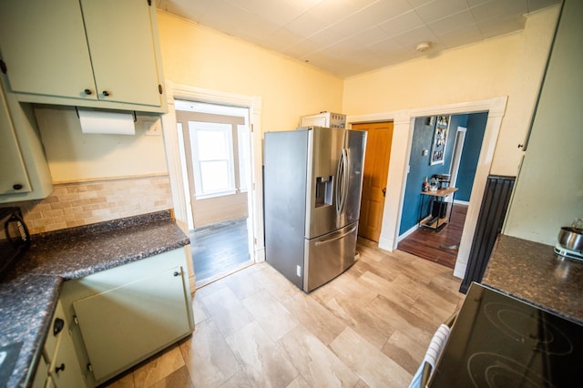 kitchen featuring stainless steel refrigerator with ice dispenser and range with electric stovetop