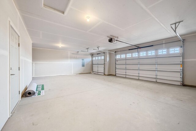garage featuring electric panel and a garage door opener