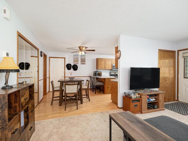 4237 Centerville Rd, Vadnais Heights, MN 55127 - living room featuring a textured ceiling, ceiling fan, light wood-type flooring, and light carpet