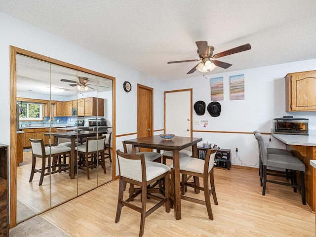 4237 Centerville Rd, Vadnais Heights, MN 55127 - dining room featuring ceiling fan, light wood finished floors, and a textured ceiling