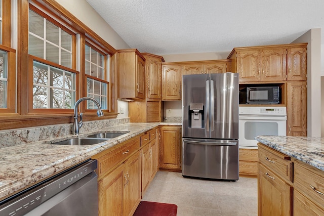 12114 260th St, Saint Cloud, MN 56301 - kitchen featuring stainless steel appliances, a sink, light stone countertops, a textured ceiling, and light tile patterned floors