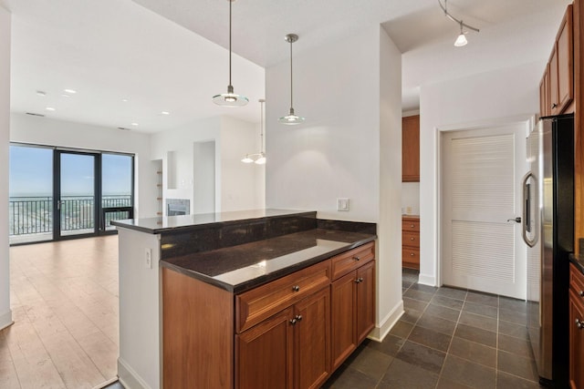 500 Grant St Unit 2707, Minneapolis, MN 55404 - kitchen with freestanding refrigerator, brown cabinets, decorative light fixtures, open floor plan, and a peninsula