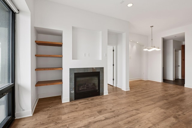 500 Grant St Unit 2707, Minneapolis, MN 55404 - unfurnished living room with baseboards, wood finished floors, a tiled fireplace, and recessed lighting