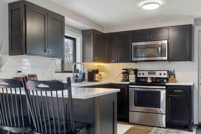16137 Ahrens Hill Rd, Brainerd, MN 56401 - kitchen with stainless steel appliances, a kitchen breakfast bar, a sink, backsplash, and light countertops