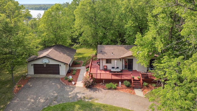 16137 Ahrens Hill Rd, Brainerd, MN 56401 - view of front of home featuring an outbuilding, a view of trees, a garage, a deck with water view, and a shingled roof