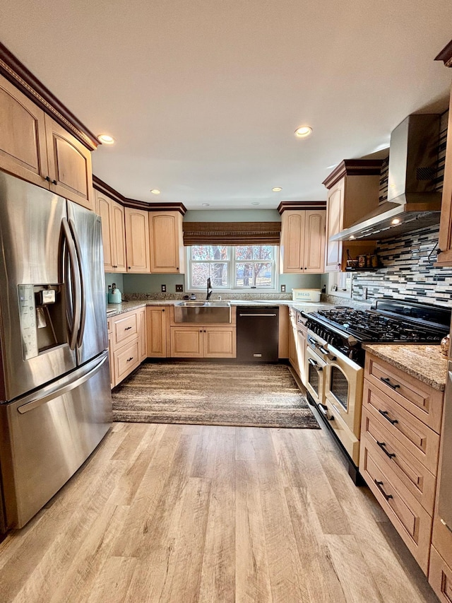 709 Riverside Dr N, North Hudson, WI 54016 - kitchen with light brown cabinets, a sink, wall chimney range hood, stainless steel appliances, and light wood-type flooring