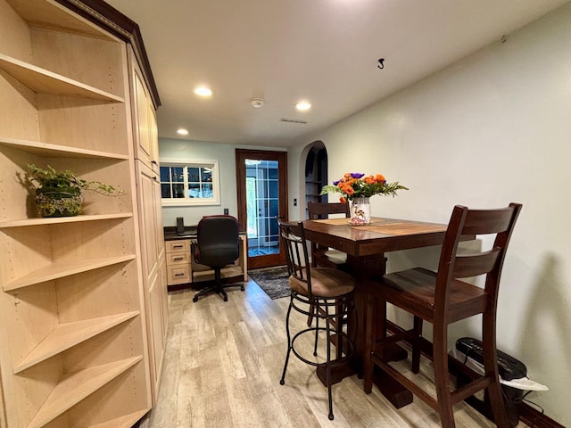 709 Riverside Dr N, North Hudson, WI 54016 - dining area featuring light wood-style flooring, recessed lighting, visible vents, arched walkways, and built in desk