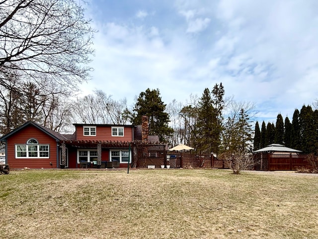 709 Riverside Dr N, North Hudson, WI 54016 - rear view of property featuring a yard, a chimney, a pergola, and fence