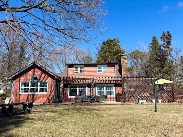 709 Riverside Dr N, North Hudson, WI 54016 - rear view of property with a chimney, a pergola, fence, and a lawn