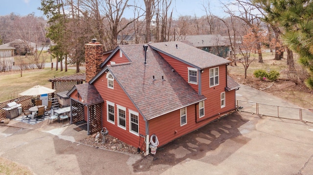 709 Riverside Dr N, North Hudson, WI 54016 - view of side of home featuring a gate, roof with shingles, a patio area, fence, and a chimney