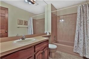 1317 Waterford Rd, Woodbury, MN 55125 - full bathroom with shower / bath combo with shower curtain, toilet, vanity, and tile patterned flooring