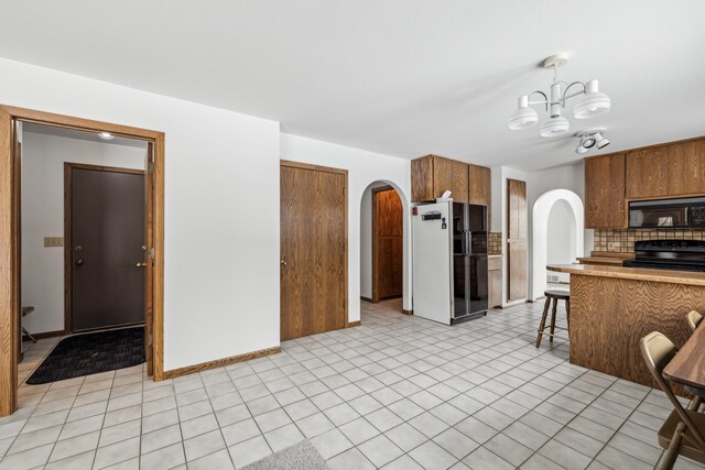 93 County 49 NW, Pine River, MN 56474 - kitchen featuring black appliances, arched walkways, brown cabinetry, a chandelier, and light countertops