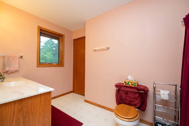 19988 Quentin Ave, Ravenna Twp, MN 55033 - bathroom featuring tile patterned floors, double vanity, baseboards, toilet, and a textured ceiling
