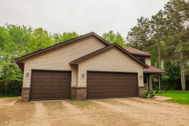19988 Quentin Ave, Ravenna Twp, MN 55033 - view of front facade featuring brick siding, dirt driveway, and an attached garage
