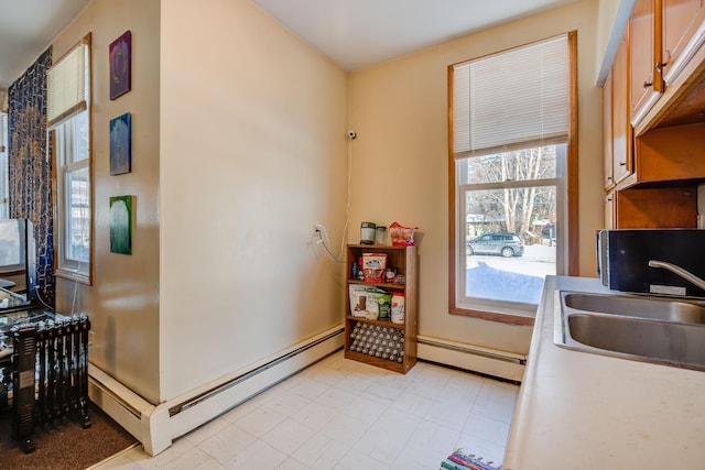 kitchen featuring a baseboard heating unit and a sink