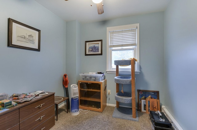 office area featuring light colored carpet, a baseboard heating unit, and a ceiling fan