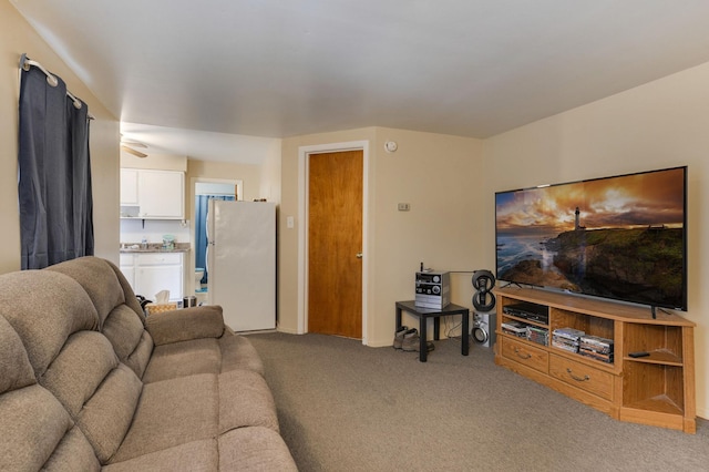 living area featuring light colored carpet and baseboards