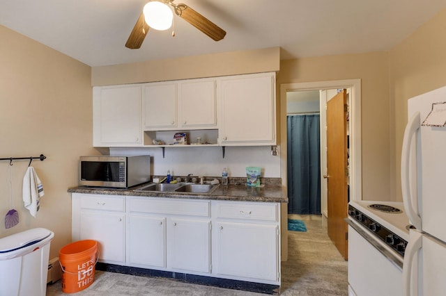 kitchen featuring open shelves, dark countertops, white appliances, a sink, and white cabinetry