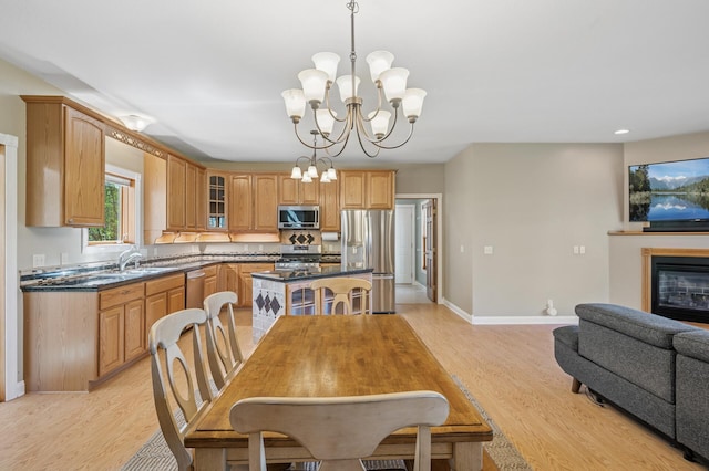 dining area featuring a chandelier, light wood-style flooring, baseboards, and recessed lighting