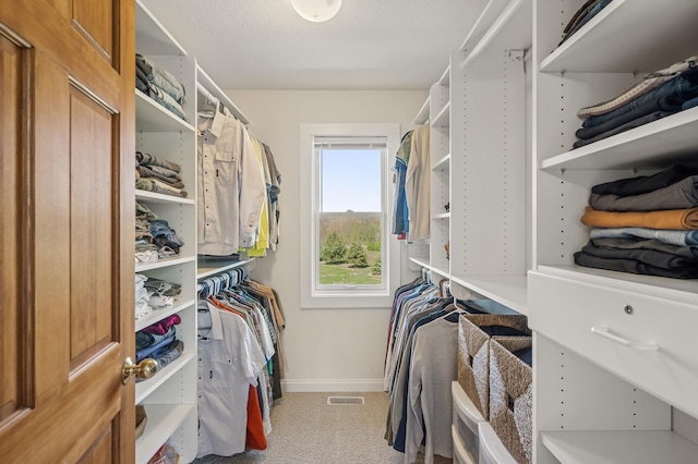 walk in closet featuring light colored carpet and visible vents