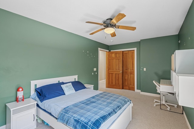 bedroom featuring light colored carpet, baseboards, and a ceiling fan