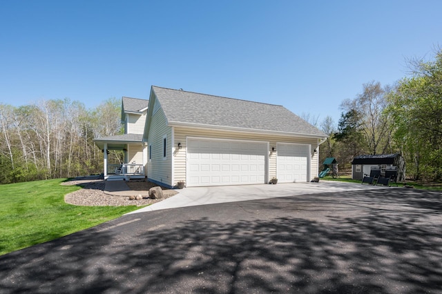 view of property exterior with a porch, roof with shingles, driveway, a garage, and a lawn