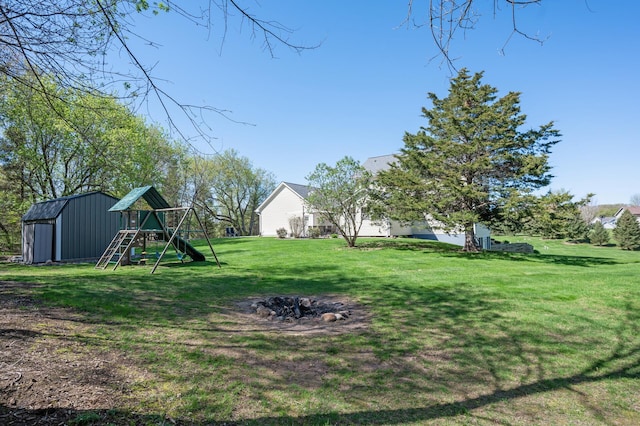view of yard featuring a playground, an outbuilding, and a shed