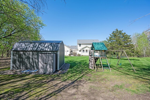 view of yard featuring an outbuilding, a storage shed, and a playground