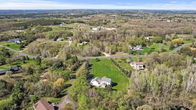 drone / aerial view featuring a wooded view
