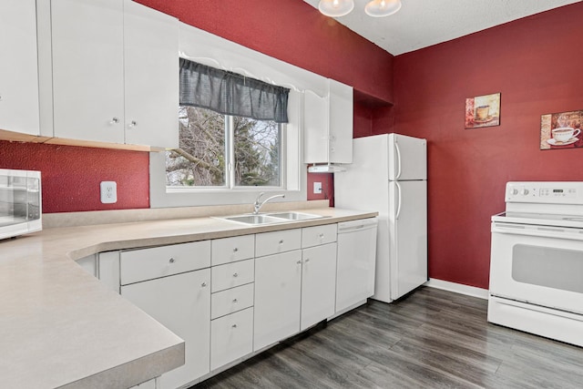 kitchen featuring light countertops, white cabinetry, a sink, and white appliances
