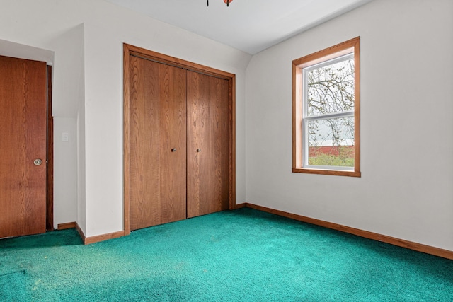 unfurnished bedroom with carpet flooring, baseboards, and a closet
