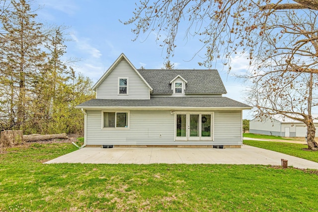 back of property with a yard, a shingled roof, and a patio