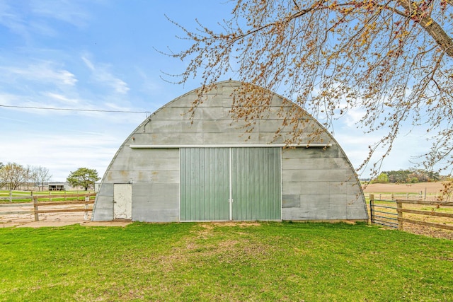 view of pole building featuring a lawn and fence
