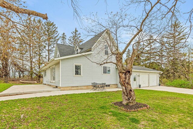 1306 70th Ave, Roberts, WI 54023 - view of side of home with a lawn, a garage, roof with shingles, and concrete driveway