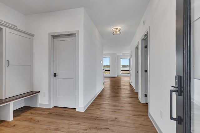 hall featuring light wood-style floors and baseboards