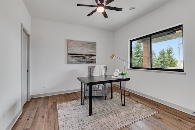 office area with ceiling fan, light wood finished floors, and baseboards