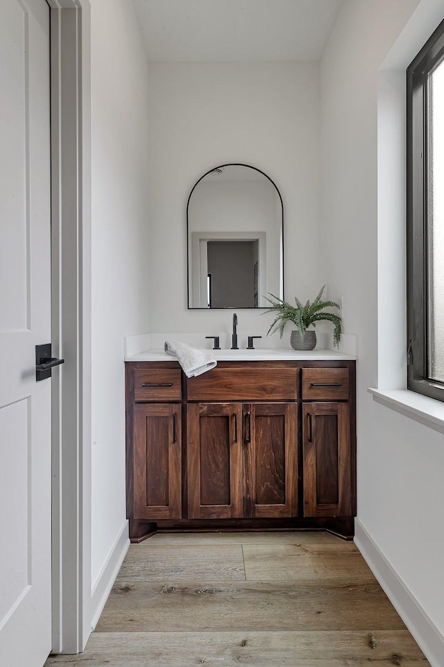 bathroom featuring wood finished floors, vanity, and baseboards