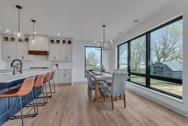 dining area featuring light wood-type flooring, a chandelier, baseboards, and recessed lighting