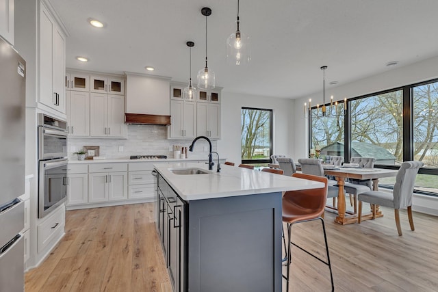 kitchen featuring a sink, light wood-style floors, plenty of natural light, white cabinetry, and recessed lighting
