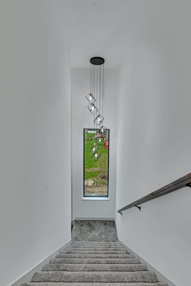 stairway featuring carpet flooring and baseboards